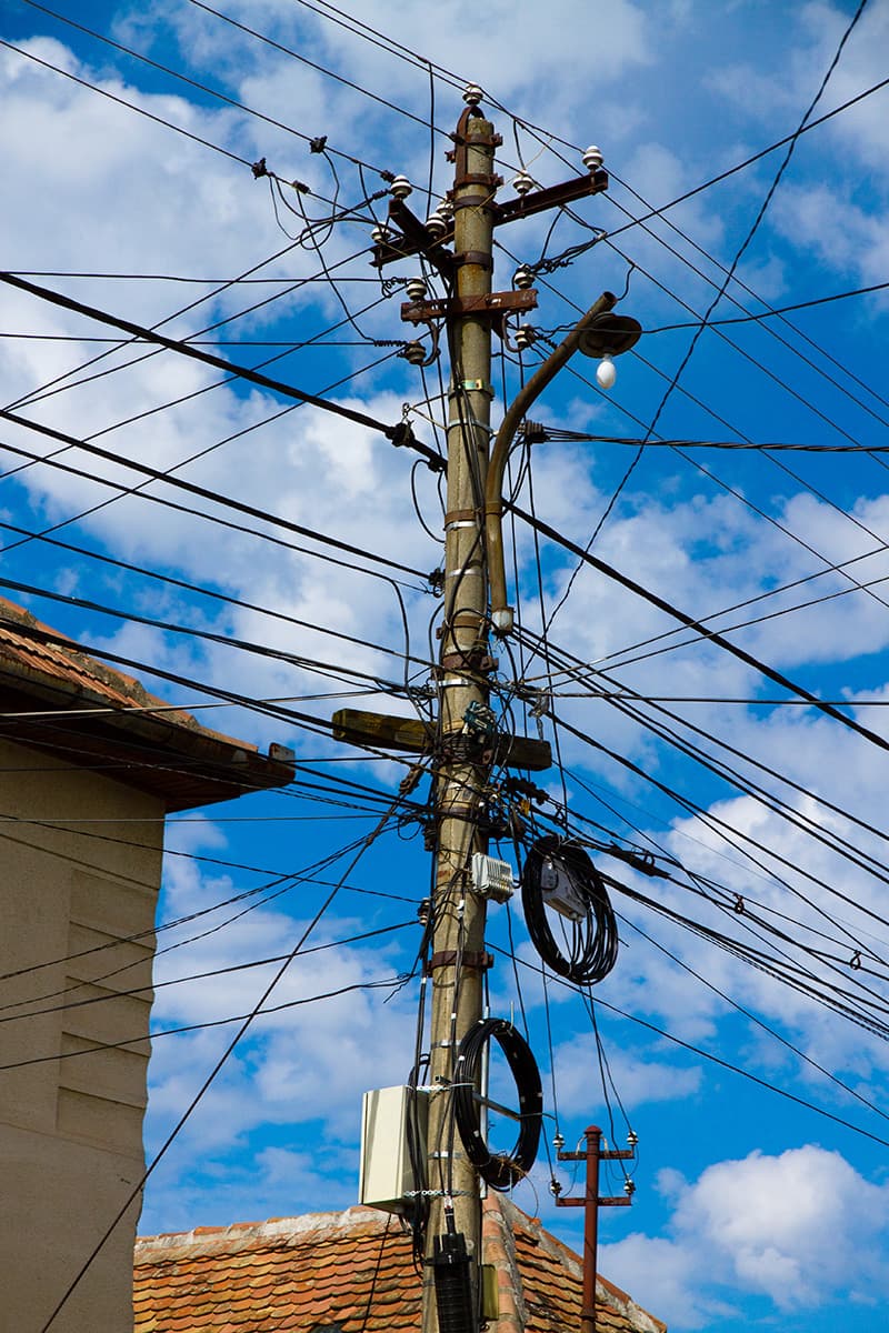 Poste de energia com cabos de rede de telecomunicações compartilhando a infraestrutura